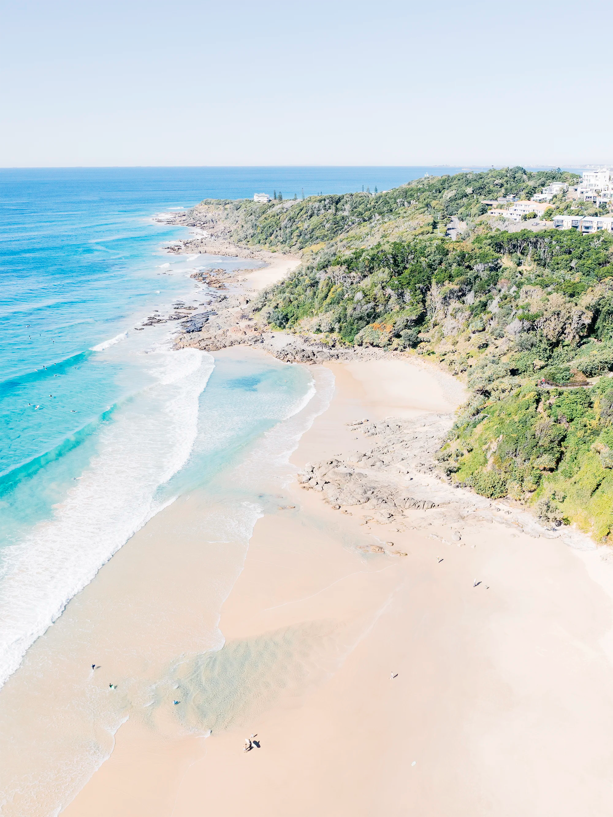 Second Bay, Coolum showing rocky headland forming a cove with sandy beach and shallow waves along shoreline