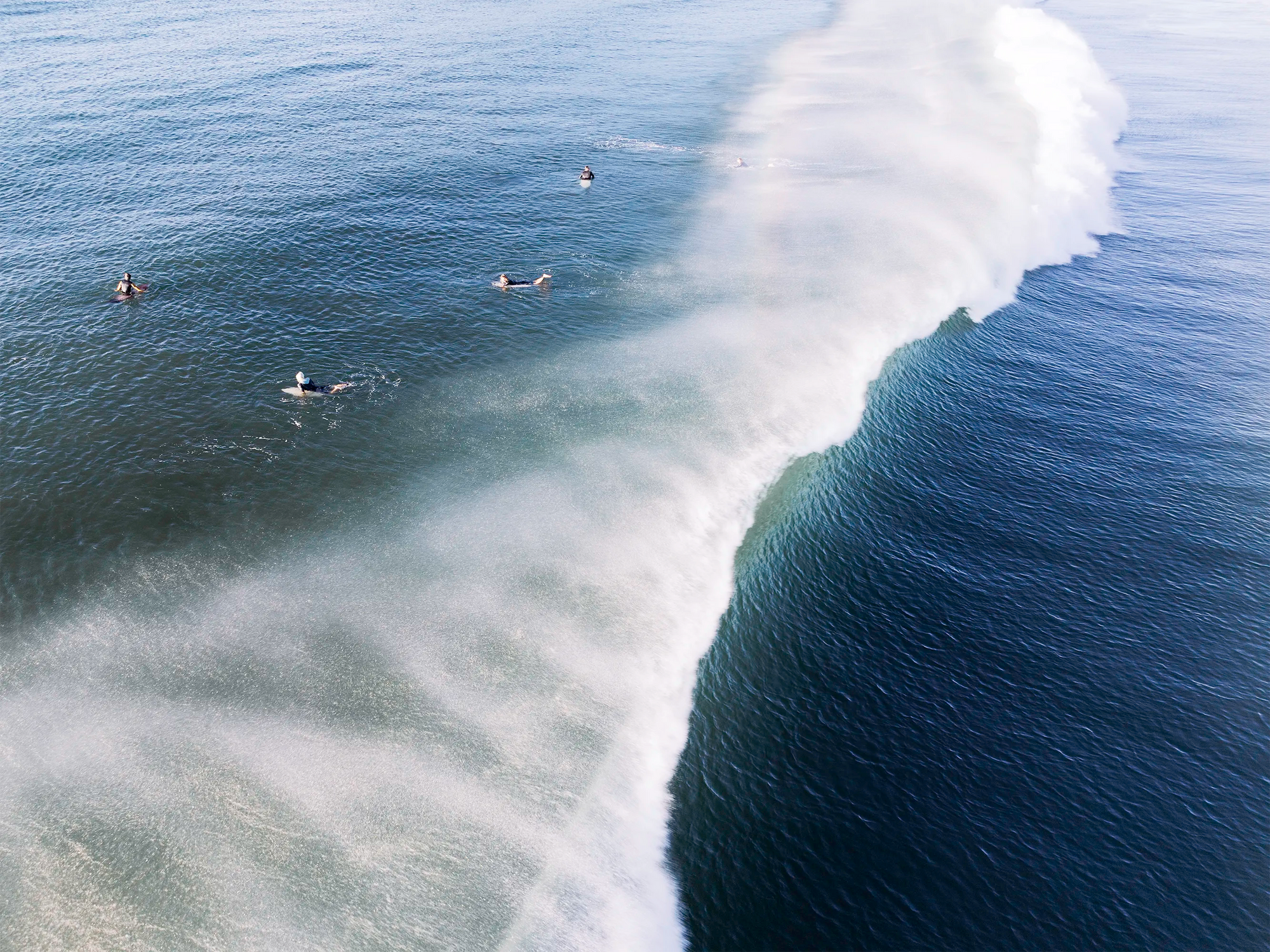 Surfers glide through ocean spray at Suffolk Park Beach, Byron Bay — a bright fine art coastal wall print.